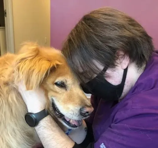 AJ hugging a golden retriever